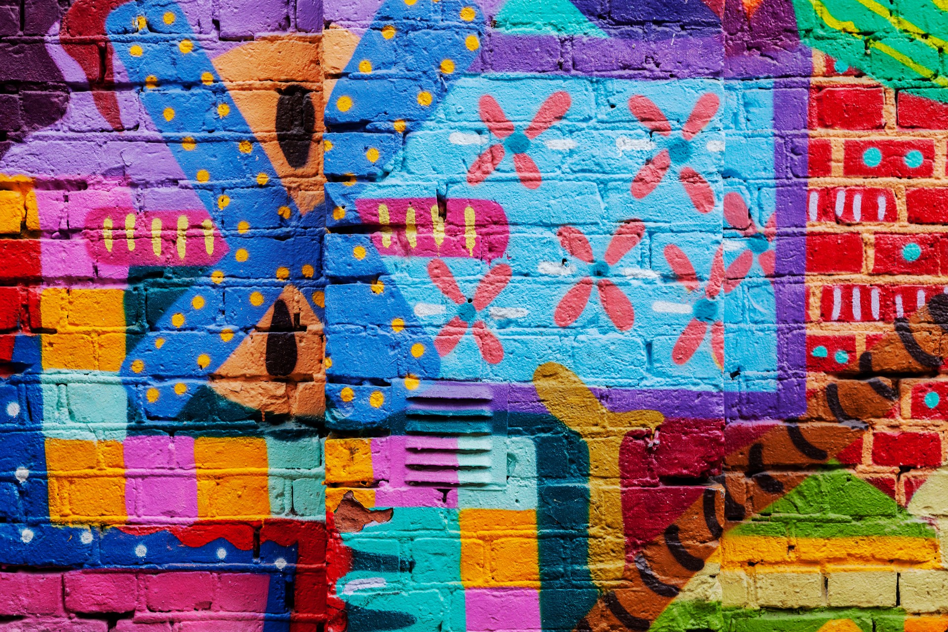 Colorful red yellow and blue graffiti on a brick wall.